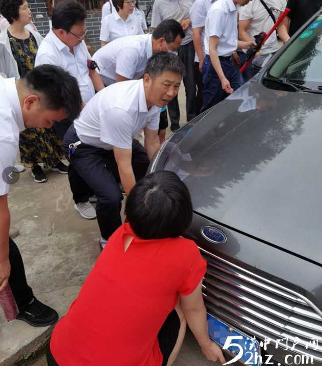 女司機開車掉進溝里，洋縣眾黨員幫忙抬車